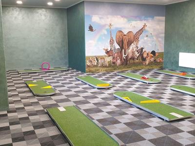 Innenraum mit grünem Teppich und Wandkunst, ideal für Yoga oder Meditation.