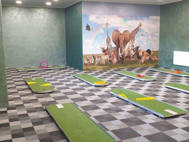 Innenraum mit grünem Teppich und Wandkunst, ideal für Yoga oder Meditation.