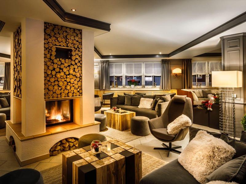 Soggiorno accogliente con camino, poltrone comode e ampie finestre con vista panoramica.