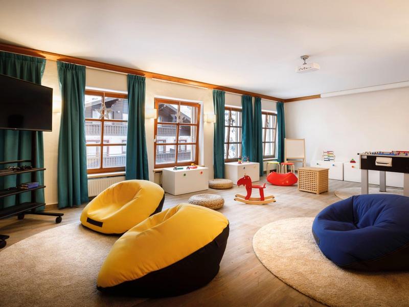 Soggiorno moderno con grandi poltrone colorate e finestre luminose.