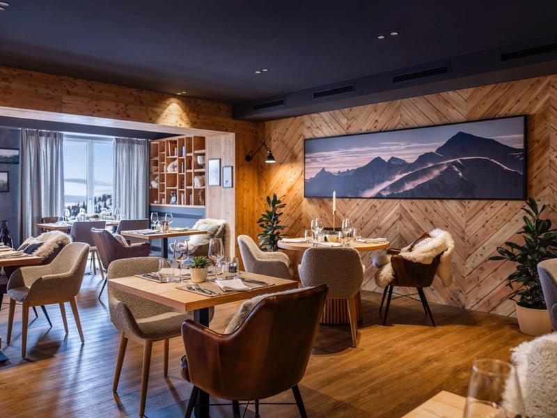 Restaurant élégant avec tables dressées et décoration en bois chaleureux.