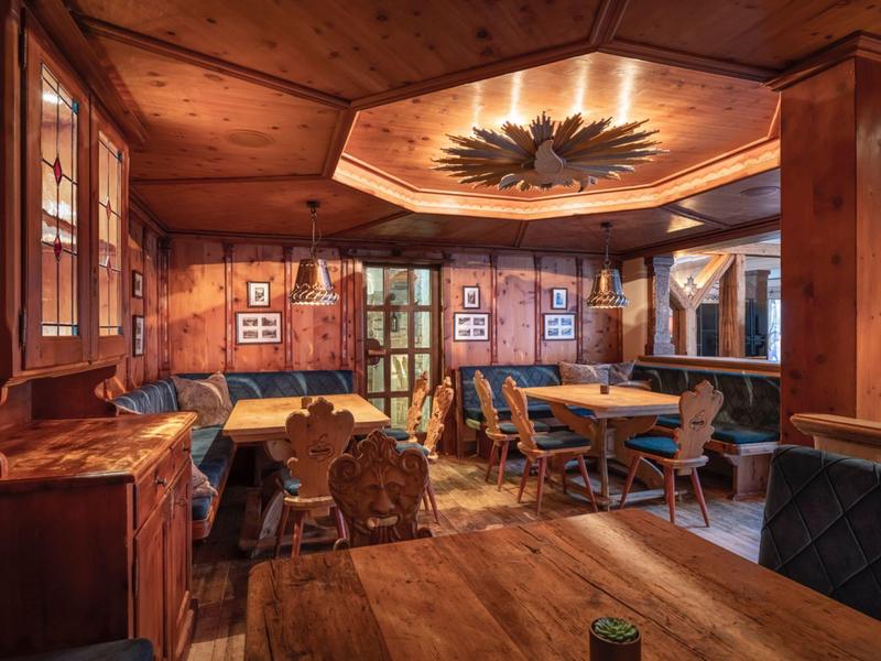 Intérieur chaleureux d'un restaurant en bois avec tables et chaises traditionnelles.