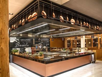 Buffet moderno con area di servizio e rastrelliere per piatti in un ristorante elegante.