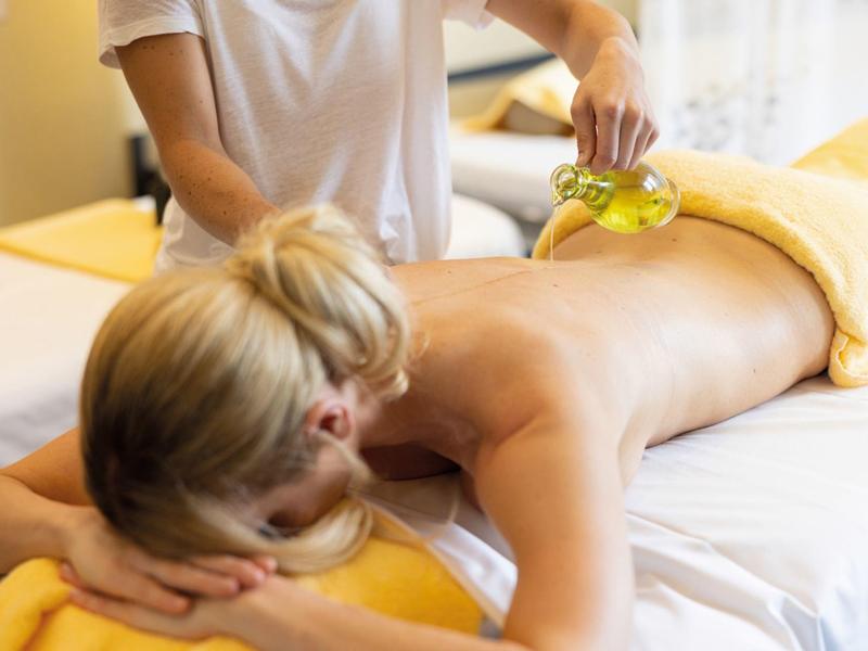 Donna che riceve un rilassante massaggio alla schiena con applicazione di olio