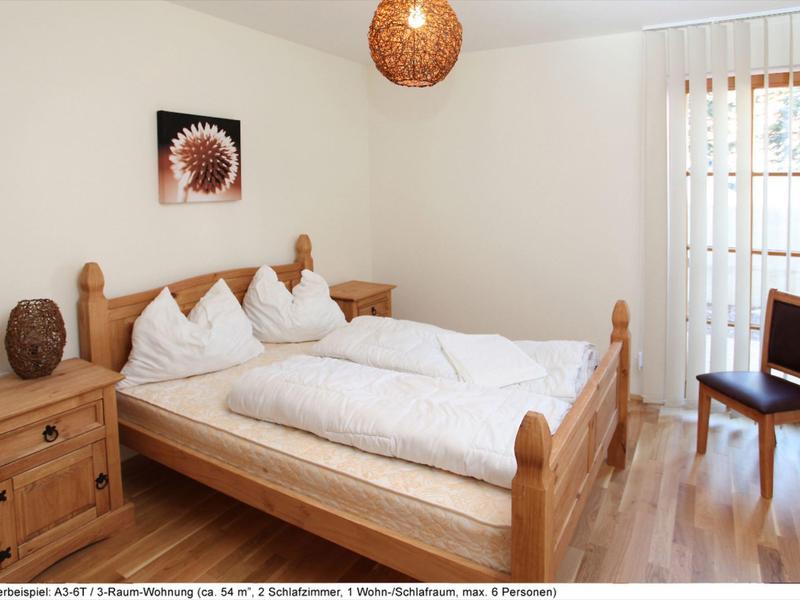 Camera d'hotel accogliente con mobili in legno, letto matrimoniale e accesso al balcone.