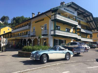 Bâtiment d'hôtel avec balcons et voitures garées par une journée ensoleillée