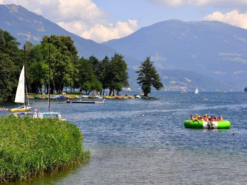 Výhled na jezero s horami a loděmi za slunečného dne.