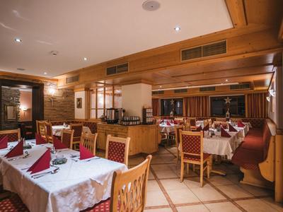 Elegantní restaurace s prostřenými stoly a teplým dřevěným dekorem.