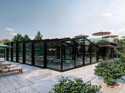 Moderní bazénová oblast se skleněnými stěnami, lehátky a venkovními slunečníky