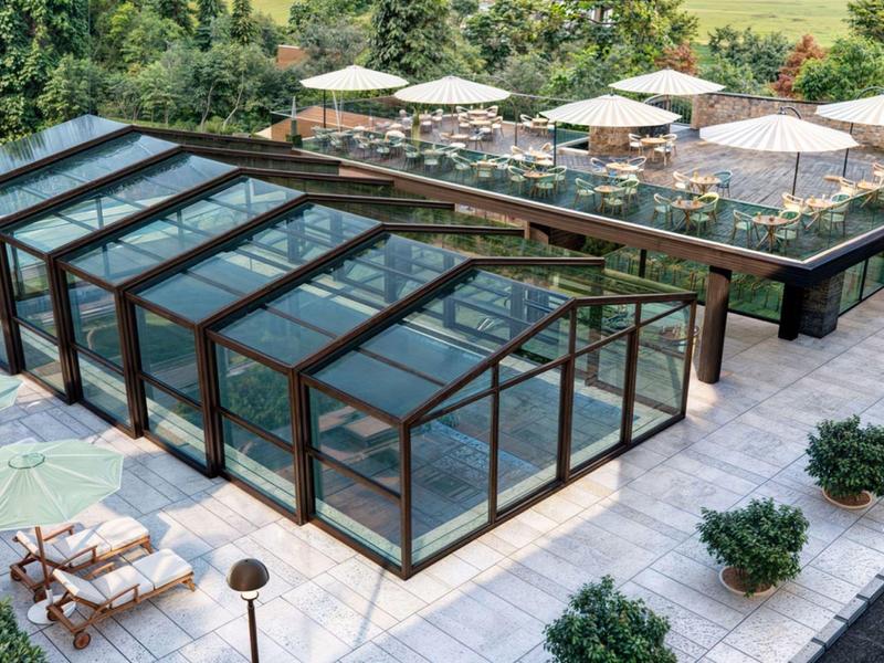 Moderner Außenbereich mit überdachtem Pool und Terrasse mit Tischen und Sonnenschirmen in grüner Umgebung