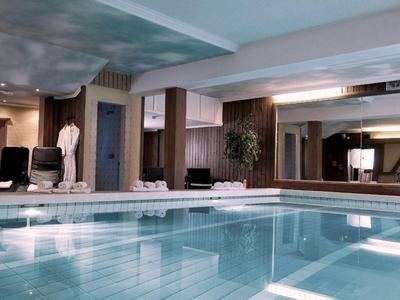 Vnitřní bazén s moderním designem, hloubkou vody a sezení podél stran.