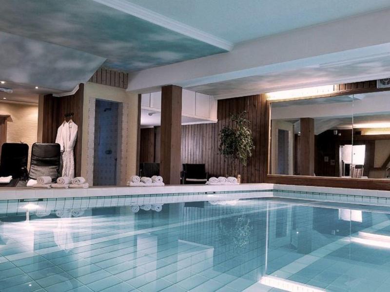 Vnitřní bazén s moderním designem, hloubkou vody a sezení podél stran.