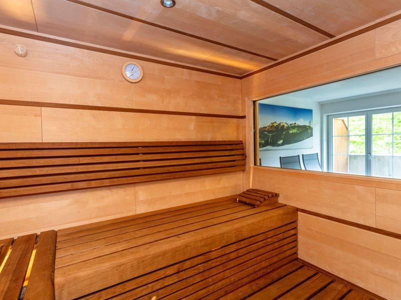 Pohodlná sauna s dřevěnými lavicemi a panoramatickými okny v hotelu.