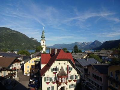 Widok na wioskę z tradycyjnymi domami na tle gór i niebieskiego nieba.