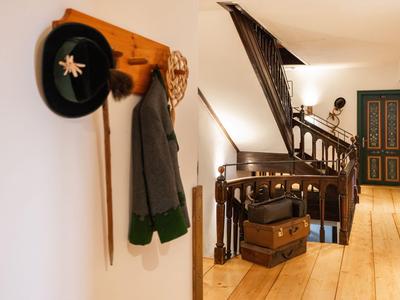 Flur mit Holzboden, Garderobe und Treppe, geeignet für Hotelgäste.
