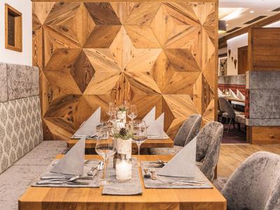 Cozy dining area with wooden table, grey chairs, and wooden wall paneling.