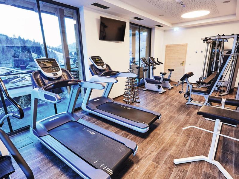Modern gym with treadmills and exercise equipment near large windows