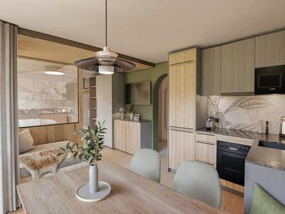 Angolo cucina moderno con zona pranzo e area salotto accogliente in una stanza luminosa.