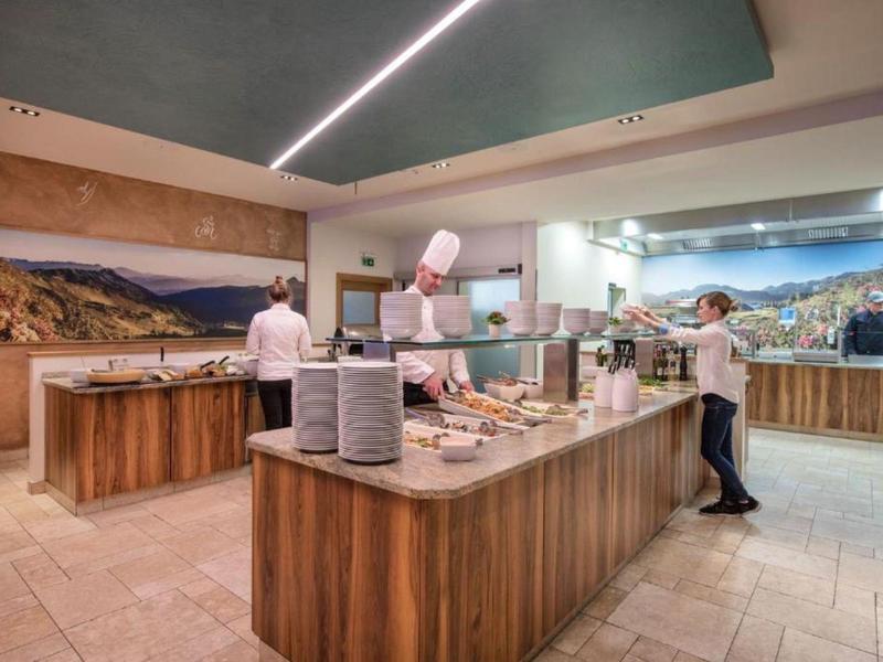 Buffetbereich in einem Hotel mit Holztheken und Köchen, die Mahlzeiten zubereiten