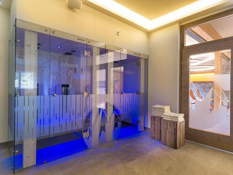 Moderner Wellnessbereich mit beleuchteter Sauna und Holzbank im Hotel.