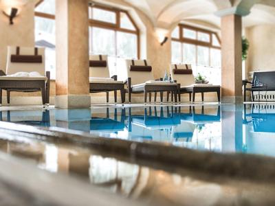 Luxuriöser Innenpoolbereich mit Stühlen und großen Fenstern in einem Hotel.