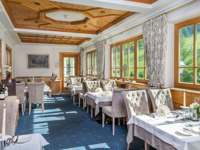 Helles Restaurant mit Fensterblick auf grüne Hügel und elegant gedeckten Tischen