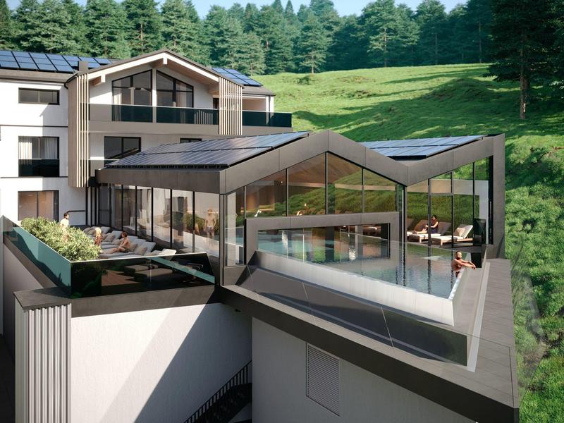 Moderner Gebäudekomplex mit großen Glasfenstern und begrüntem Dach in ländlicher Umgebung.