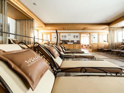 Helle, moderne Lounge mit gemütlichen Liegen und Kissen in warmen Tönen.