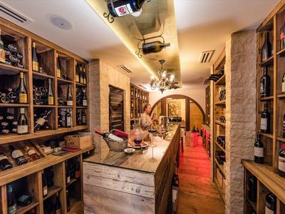 Gemütlicher Weinkeller mit Holzregalen und einem rustikalen Holztresen.