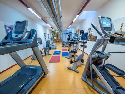 Moderner Fitnessraum mit Laufbändern und Ergometern in einem Hotel.