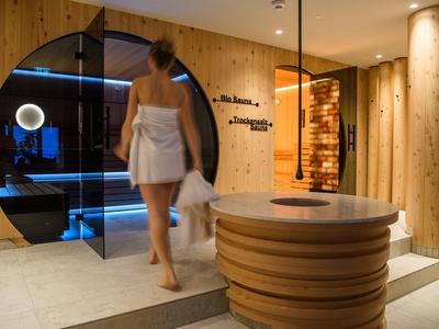 Moderner Spa-Eingang mit Holzwänden und runder Rezeption.