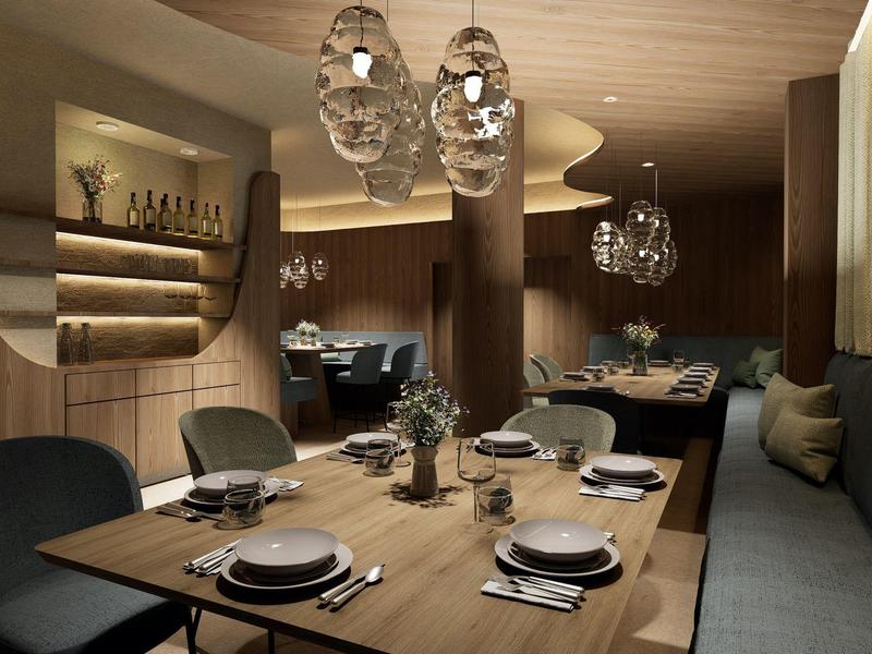 Elegantes Restaurant mit Holztischen, gedeckten Plätzen und modernen Lampen in warmem Licht.