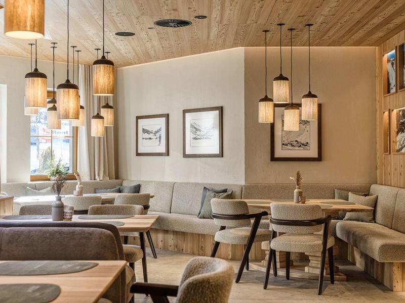 Modern eingerichteter Gastronomiebereich mit Holzmöbeln und warmem Licht.