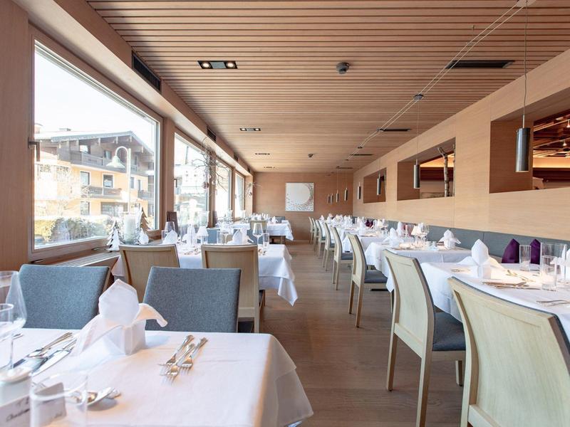 Helles, modernes Restaurant mit großen Fenstern, gedeckten Tischen und bequemen Stühlen.