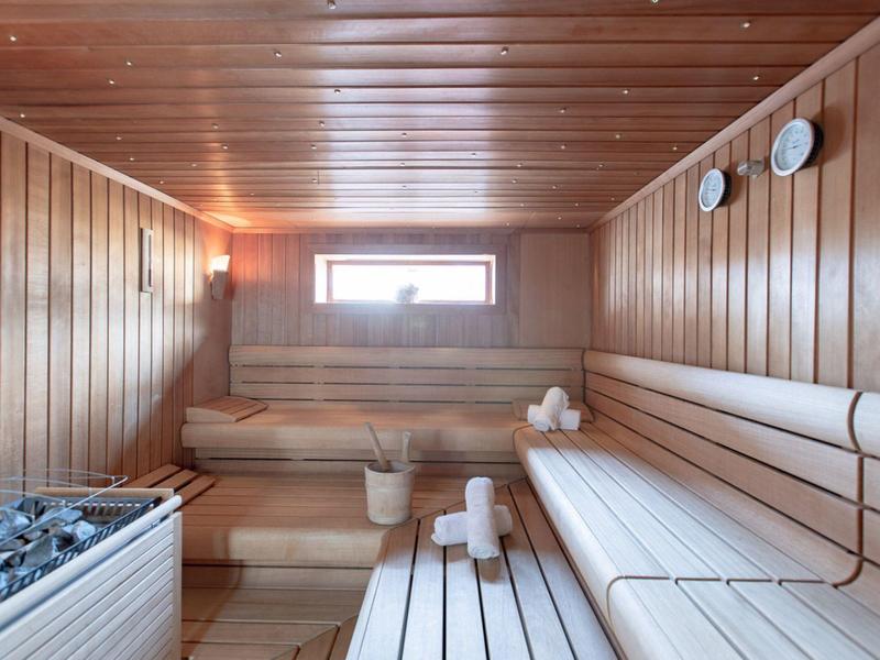 Helle finnische Sauna mit Holzbänken und Saunasteinen
