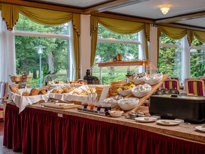 Buffet mit verschiedenen Brotsorten und Gebäck in eleganter Hotel-Lounge mit großen Fenstern.