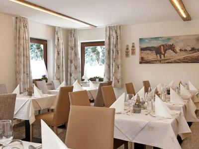 Sala da pranzo luminosa con tavoli apparecchiati e sedie comode.