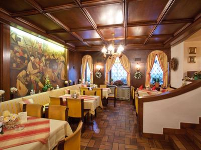 Traditionell eingerichteter Hotel-Restaurantbereich mit Holzmöbeln und Wandgemälde.