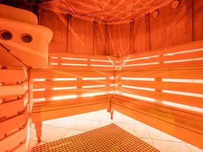 Innenansicht einer Sauna mit mehrstufigen Holzbänken und warmer Beleuchtung.