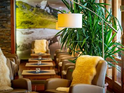 Gemütliche Hotel-Lounge mit bequemen Sesseln, großzügigen Fenstern und warmem Licht.