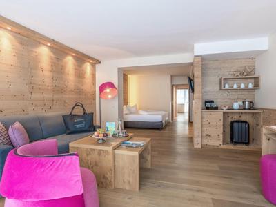 Camera d'hotel moderna con accenti in legno, posti a sedere comodi e vista sulla camera da letto.