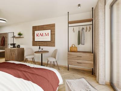 Camera d'hotel luminosa con letto matrimoniale, area salotto, mobili in legno e balcone con vista sulle montagne.