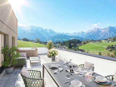 Terrazza moderna con zona pranzo con vista su colline verdi e montagne innevate.