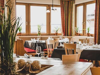 Cozy hotel dining room with wooden furniture, large windows, and table decorations.