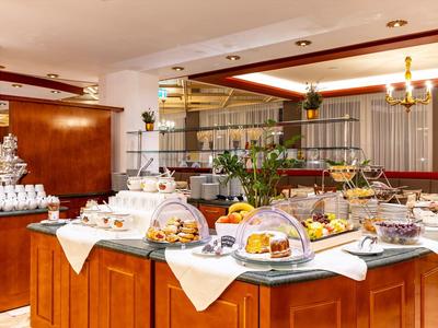 Buffet mit vielfältigen Speisen auf Holztresen in hellem, gemütlichem Raum mit weißen Wänden.