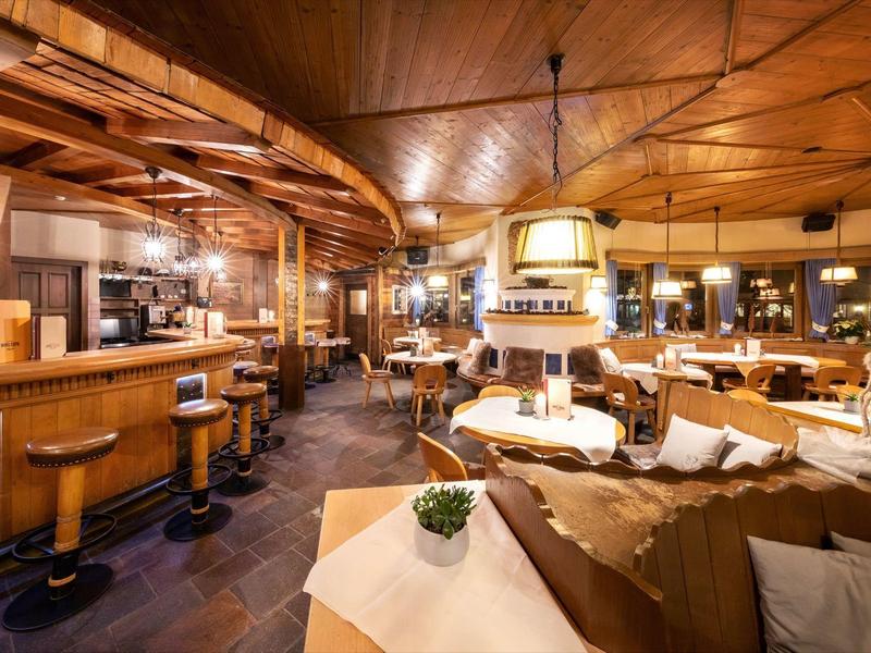 Gemütliches Restaurant mit Holzdecke, Bar, Ledersofas und warmem Licht, elegantes Interieur.