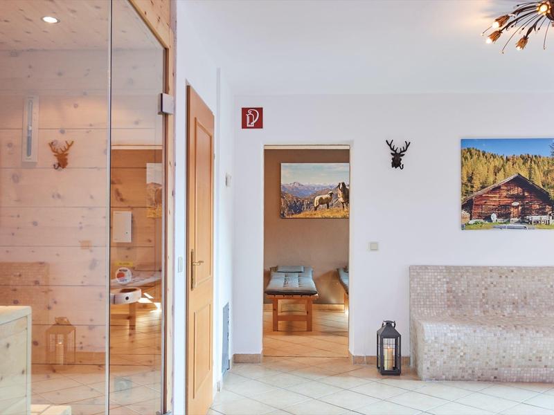 Heller Wohnraum mit Holzmöbeln, eingerahmten Bildern an der Wand und gemütlichem Sofa.