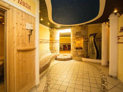 Espace bien-être chaleureux avec des détails en bois, des bancs ronds et un éclairage tamisé.