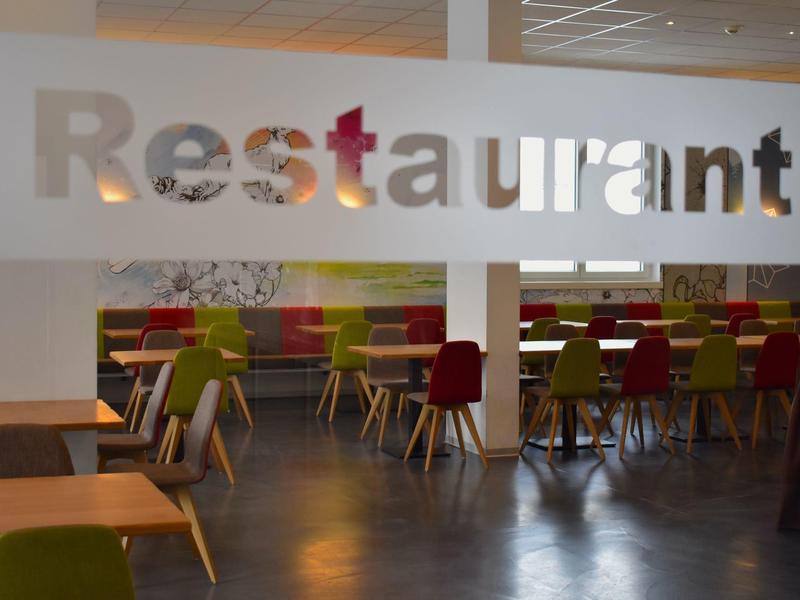 Restaurant moderne avec des chaises colorées et un design propre et simple.