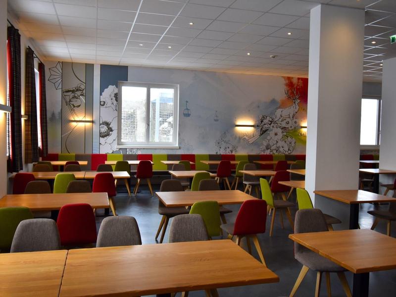 Salle à manger moderne avec des chaises colorées et des tables dans un hôtel